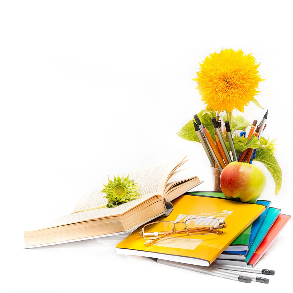 Des livres, une pomme, des stylos et une fleur jaune